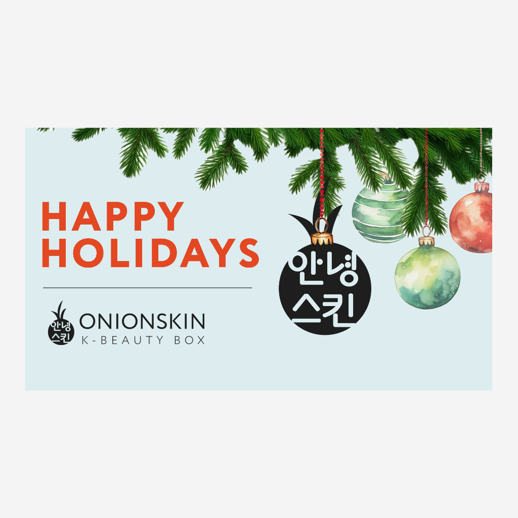 ONION SKIN logo hanging as an ornament on Christmas tree by other ornaments with message of Happy Holidays.