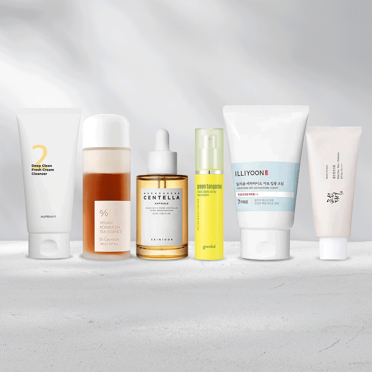 Skincare products including cleanser, toner, serum, moisturizer, eye cream and suncare standing next to each other.