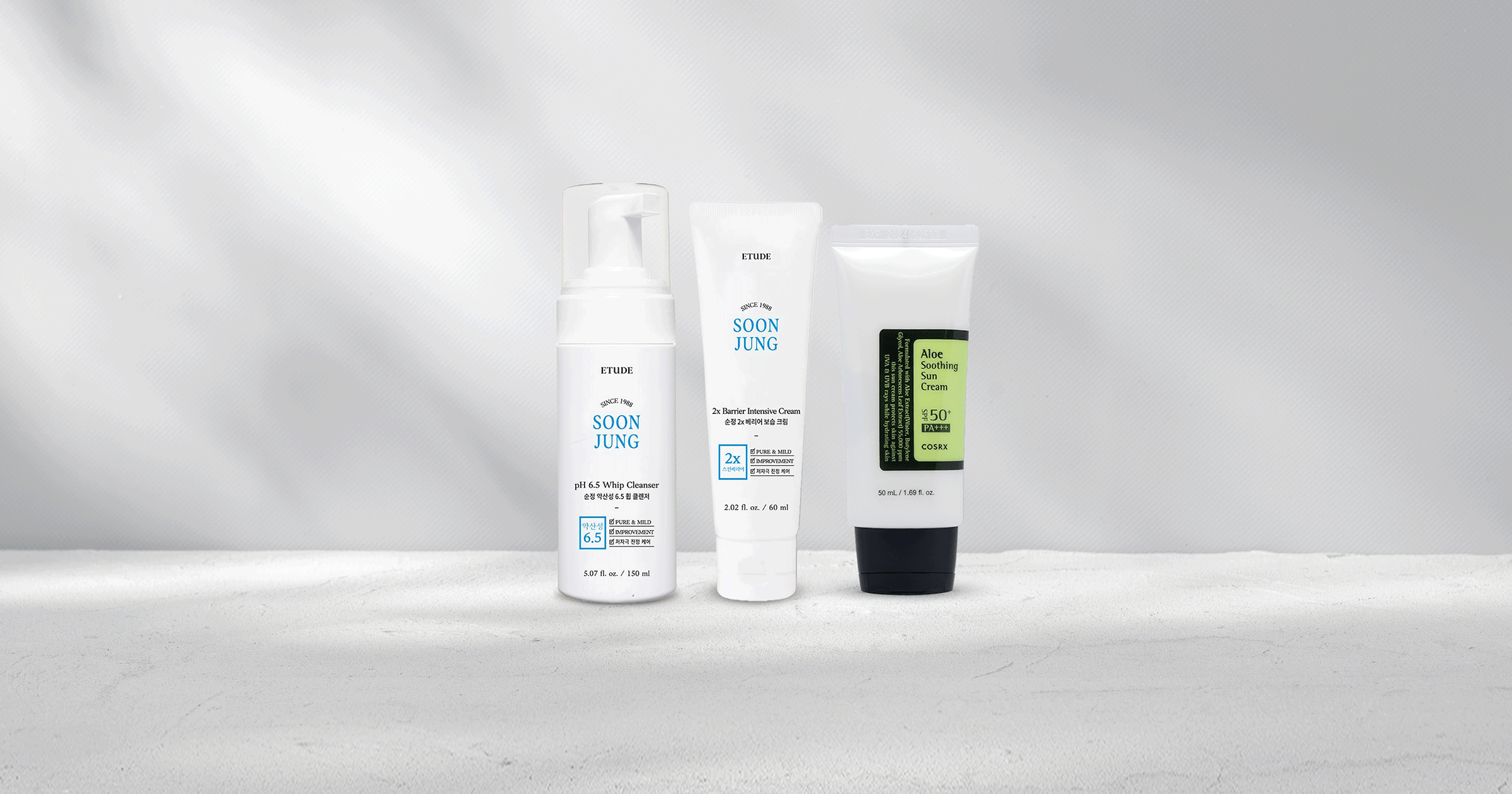 Skincare products including cleanser, moisturizer, and suncare standing next to each other.