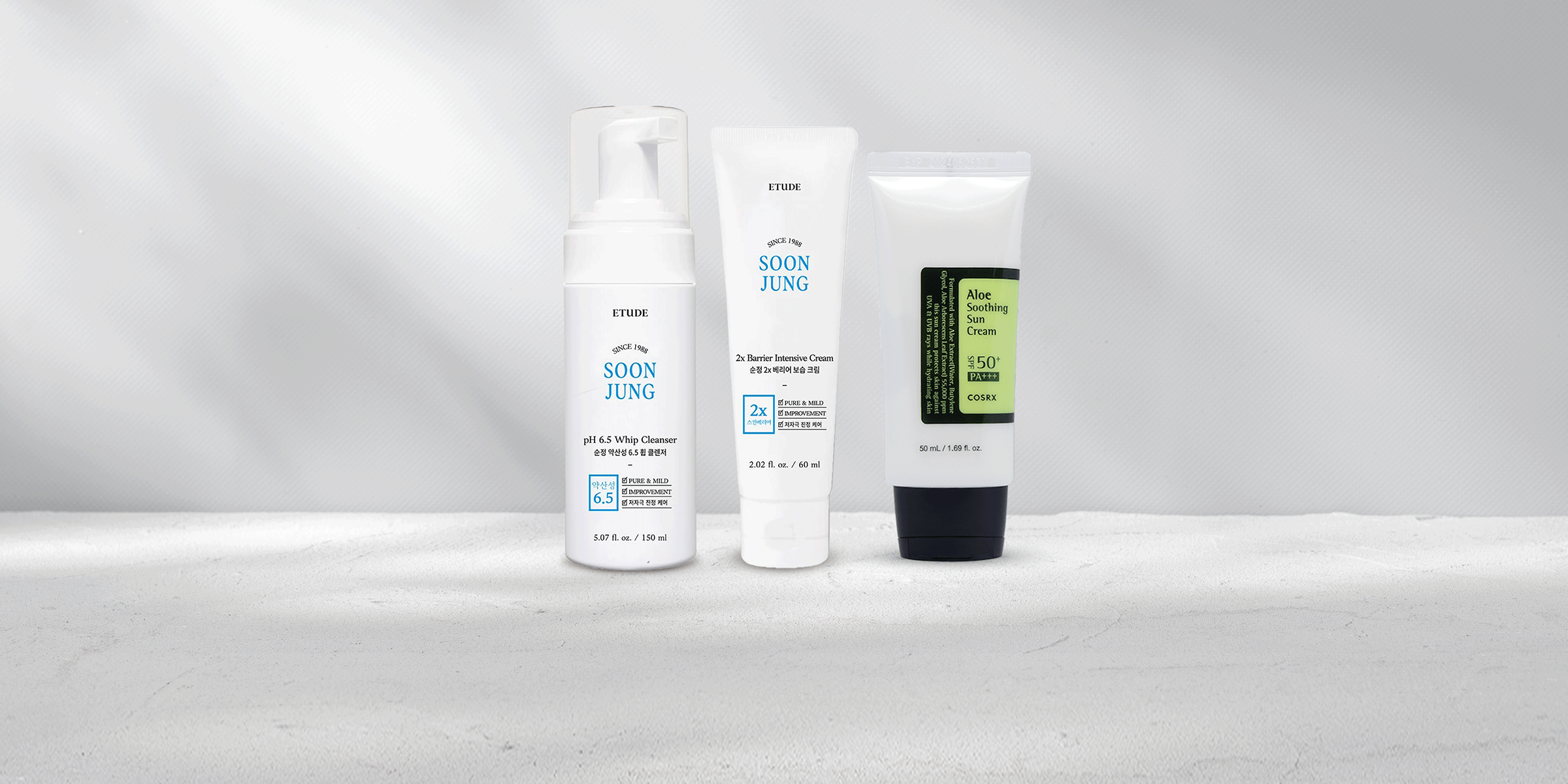Skincare products including cleanser, moisturizer, and suncare standing next to each other.